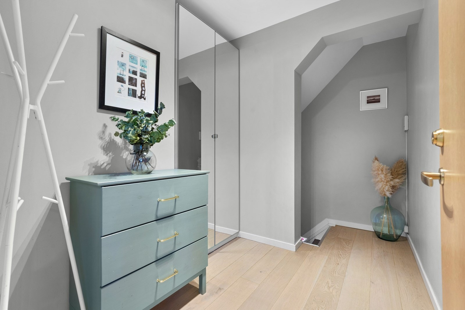 Leiligheten har en lys og innbydende entré med praktisk garderobeskap med plass til å henge fra seg yttertøy og sette fra seg sko Galleribilde