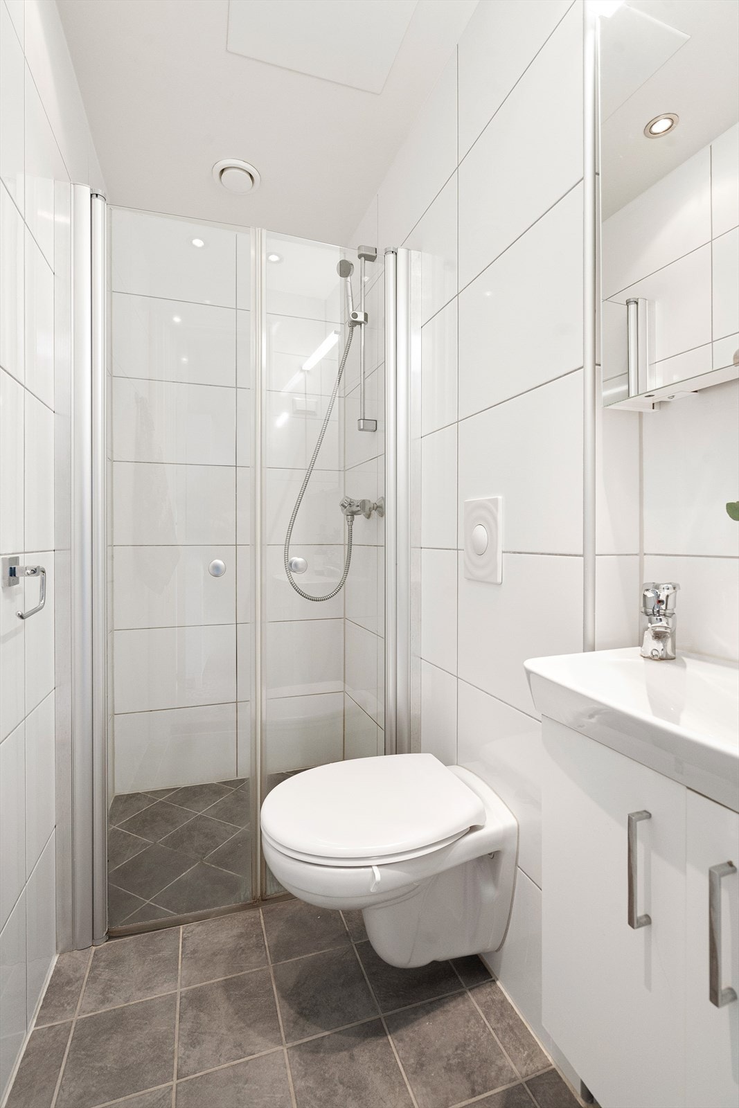 Tidløst bad fra 2010 med behaglig gulvvarme, flislagte overflater og downlights i himling. Galleribilde