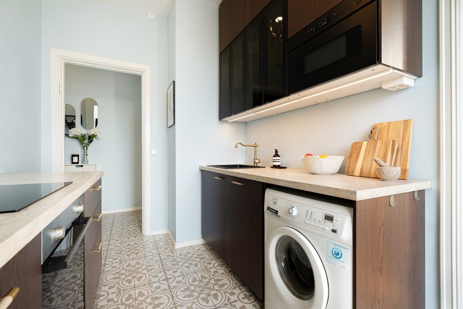 Stilig innredning med glatte laminerte fronter og benkeplate i laminat med nedsenket oppvaskkum. Galleribilde