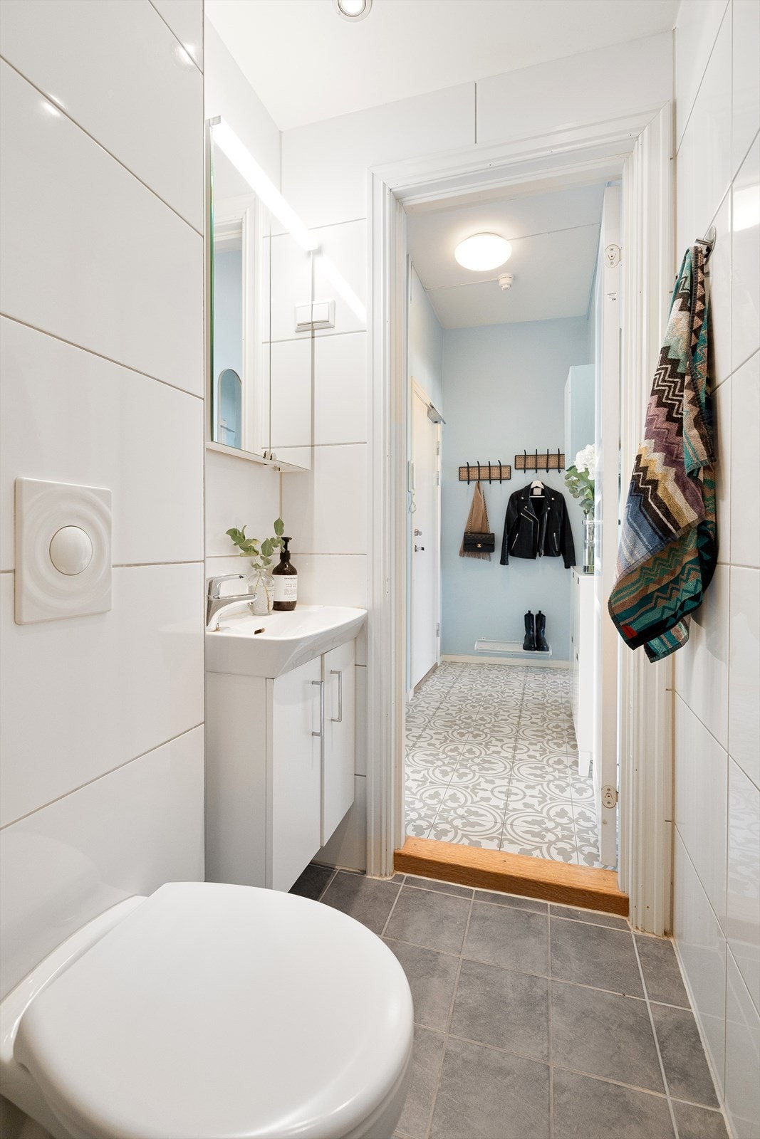 Badet er utstyrt med innfellbare dusjdører, servantskap og veggmontert wc. Galleribilde