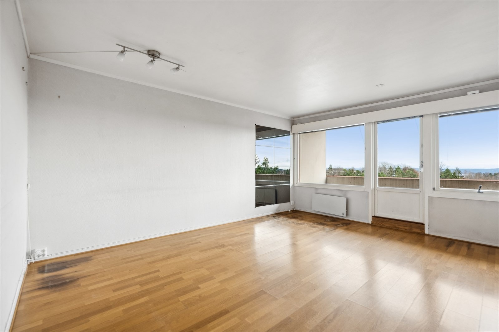 Stue med store vindusflater og utgang til balkong. Galleribilde