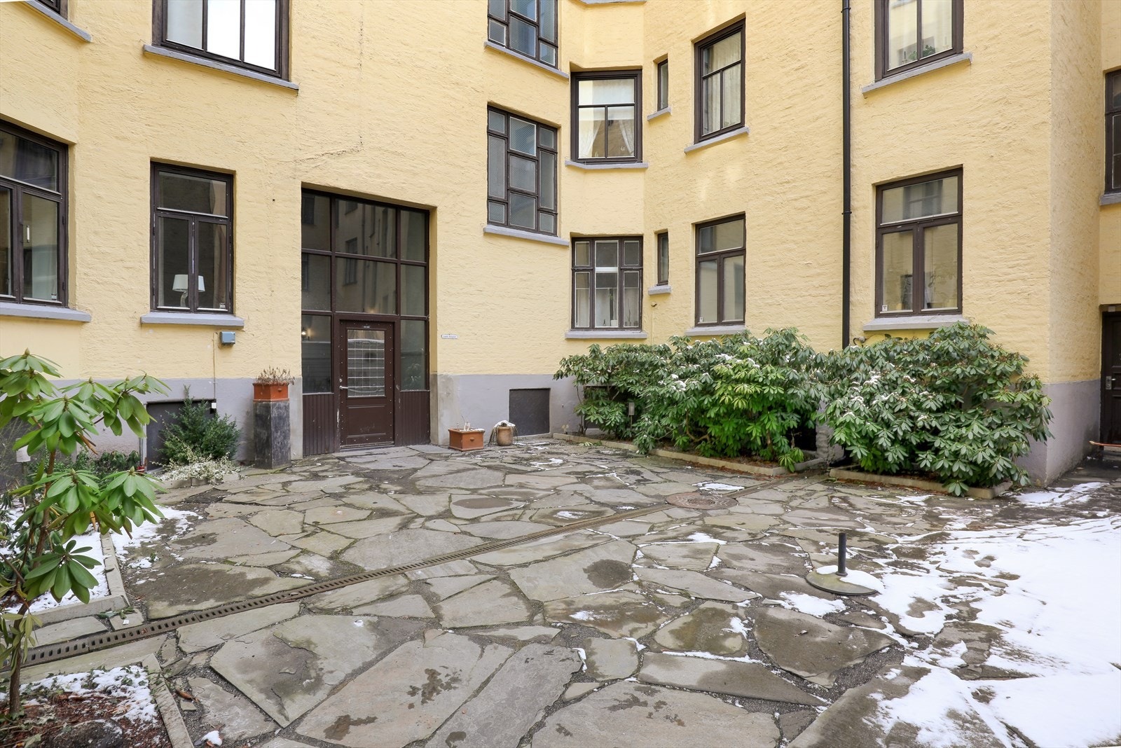 Hyggelig bakgårdsrom som sommerstid er møblert med rottingmøbler og grill som kan benyttes av beboerne Galleribilde
