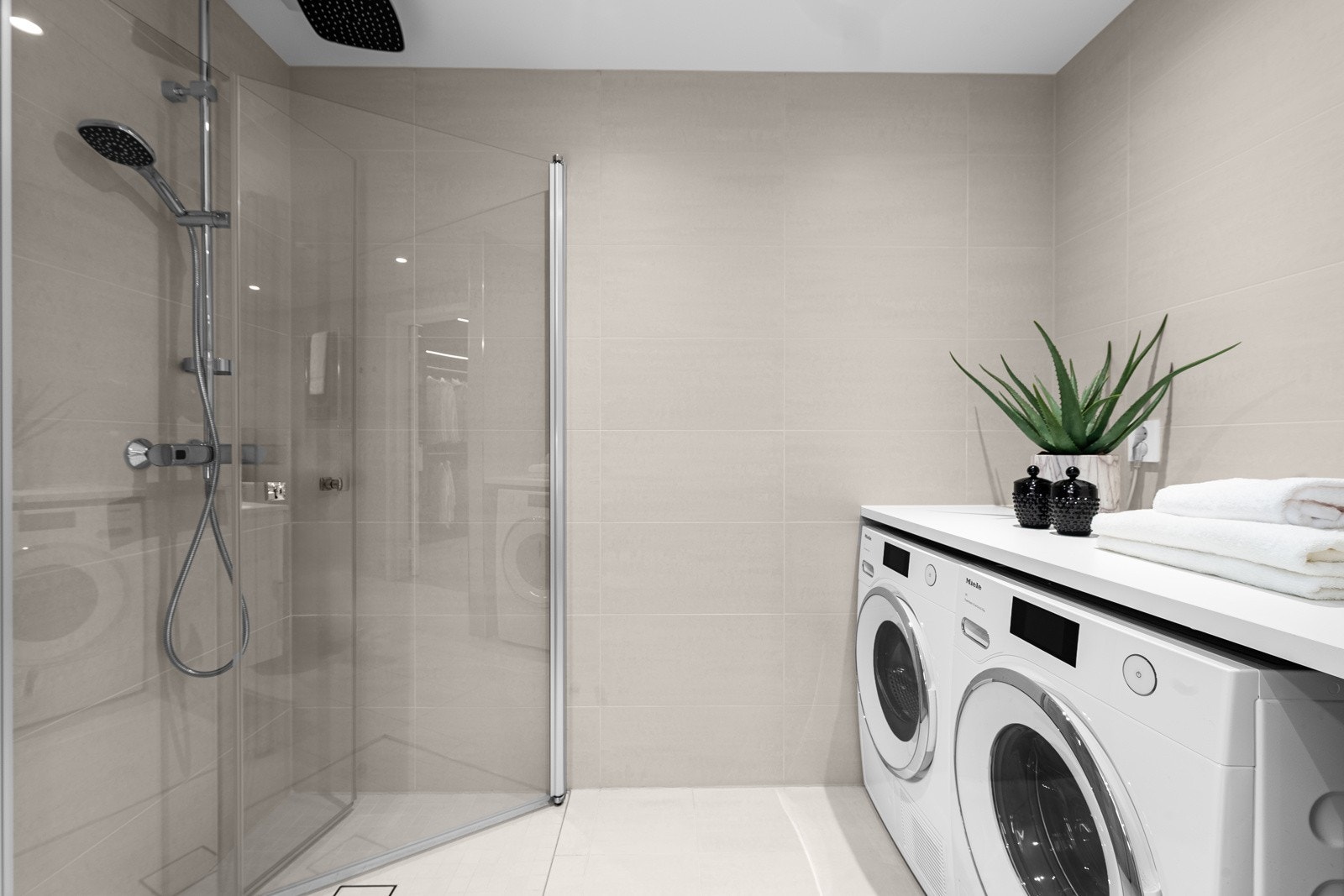 Dette badet har også opplegg for vaskemaskin og tørketrommel under en arbeidsbenk. Galleribilde