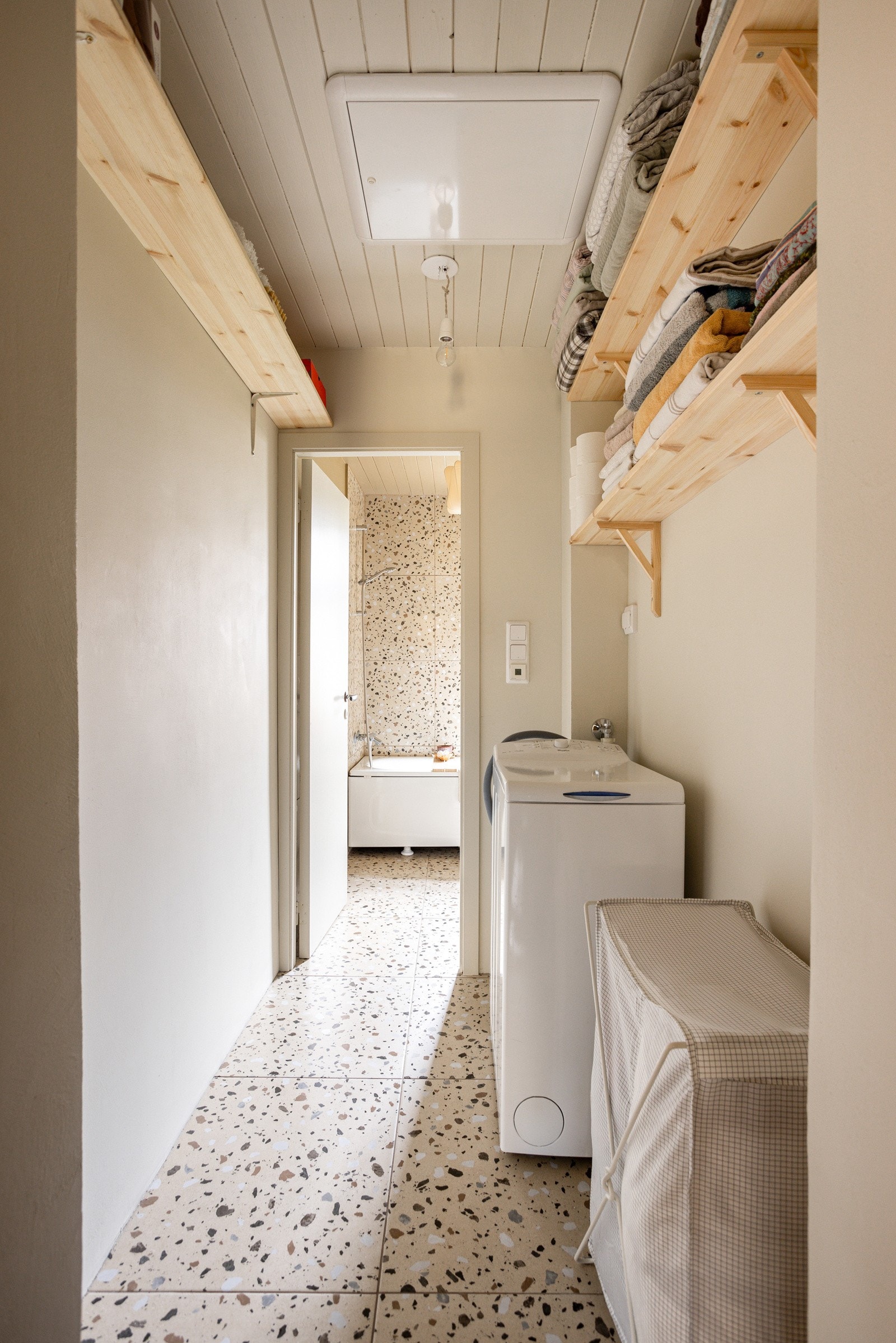 I gangen utenfor baderommet er det plass og opplegg for vaskemaskin, samt praktisk vegghengte hyller for oppbevaring. Galleribilde