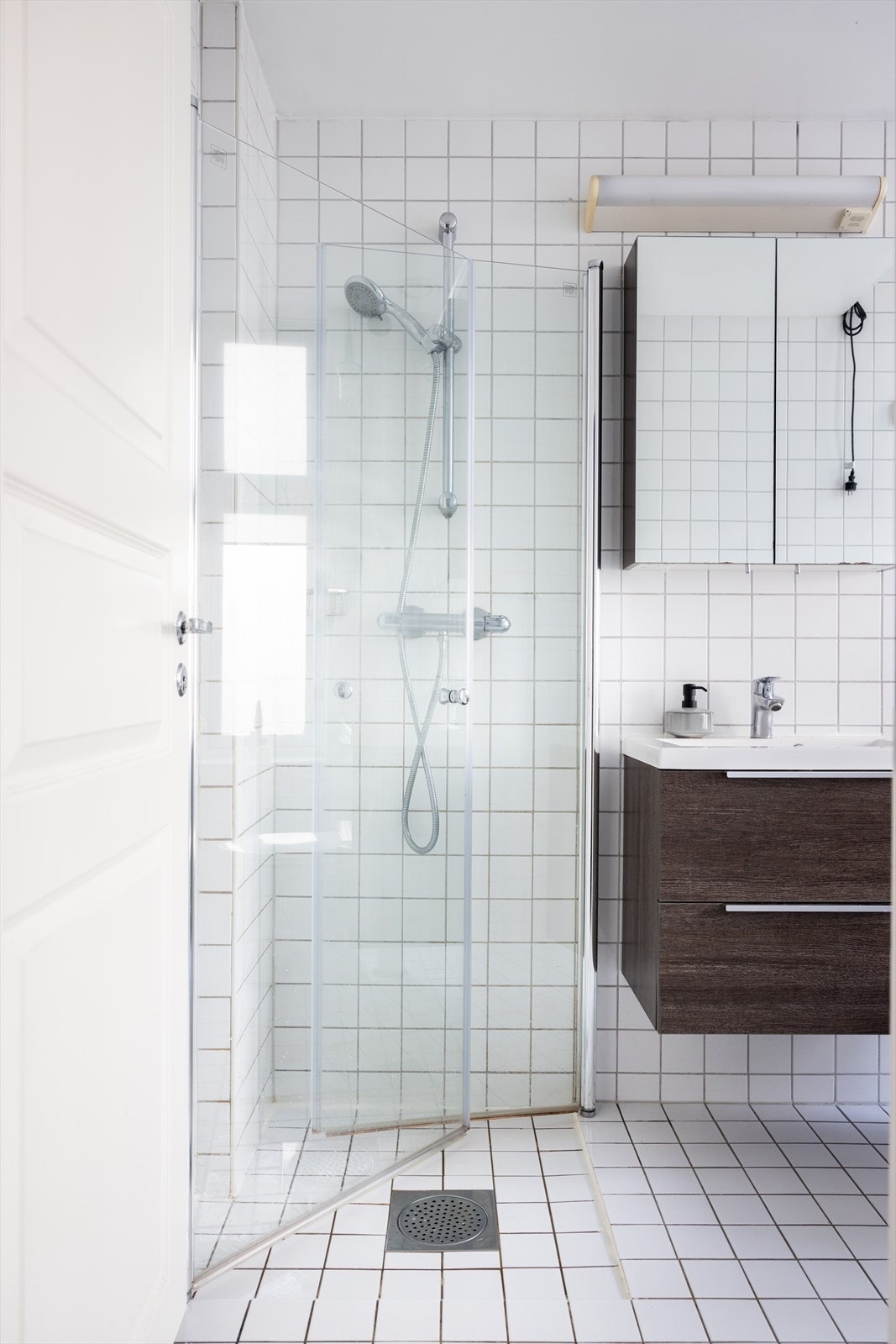 Badet er innredet med klosett, servant med innredning, speilskap m/lys og dusjhjørne med innfellbare glassdører. Galleribilde