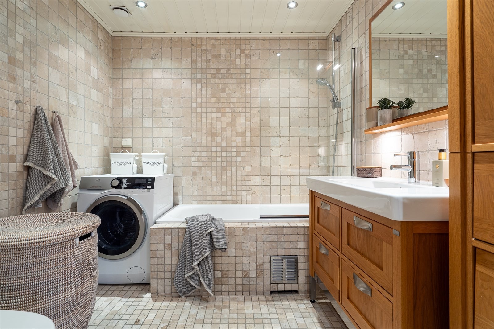 Et pent flislagt baderom med opplegg til vaskemaskin. Galleribilde