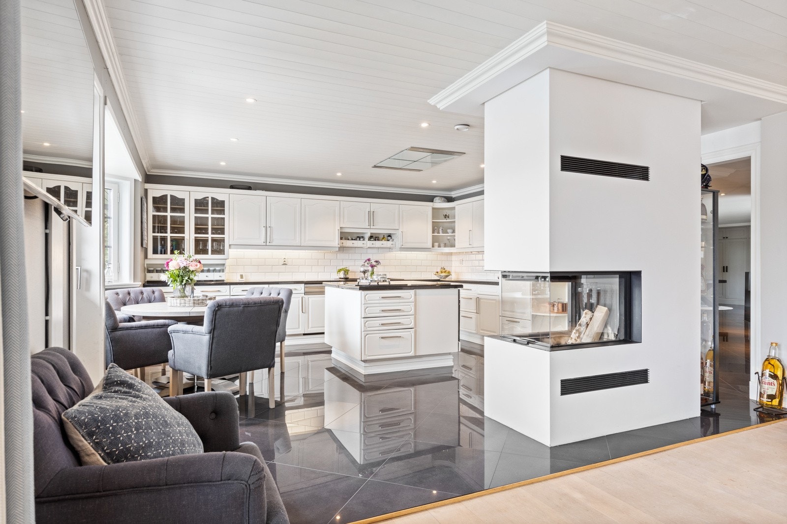 Moderne og stilig peis med glass fra tre sider. Peisen sees fra kjøkken, spisestue, forstue og stue, samt ute fra terrassen. Galleribilde