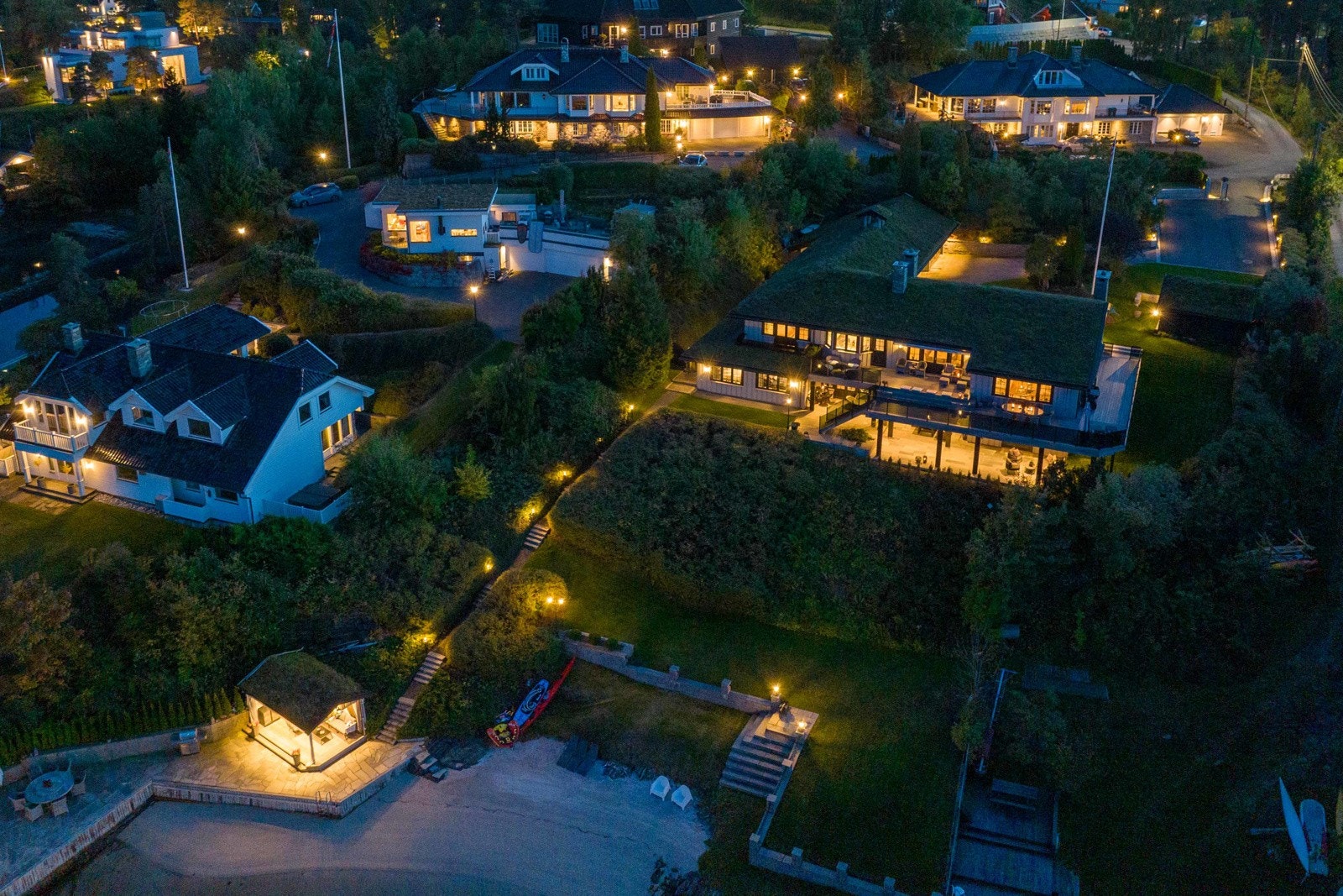 Stemningsfull belysning fra innkjøring og ned til båthus. Galleribilde