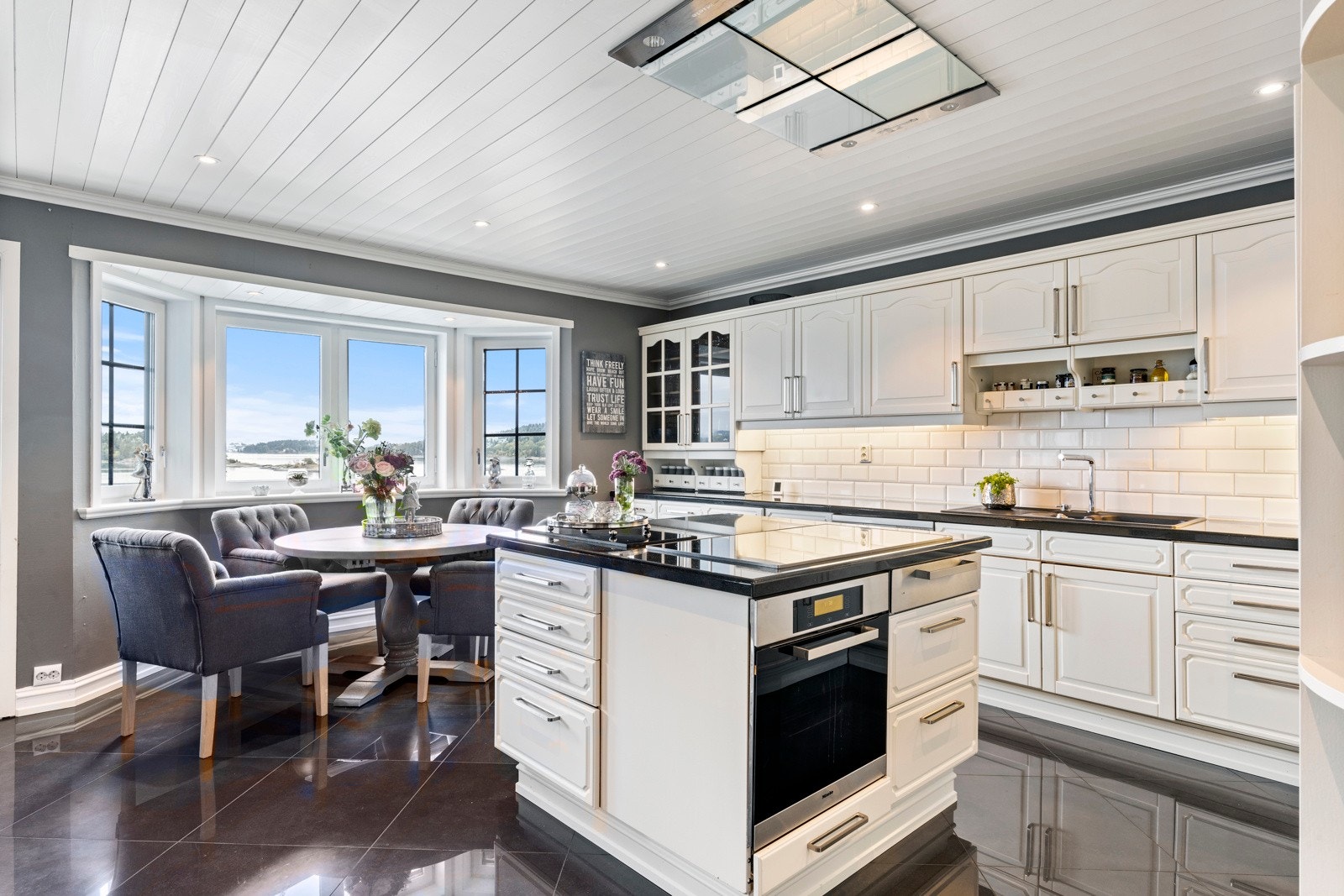 Hvit kjøkkeninnredning med profilerte fronter og god oppbevarings- og benkeplass. Galleribilde