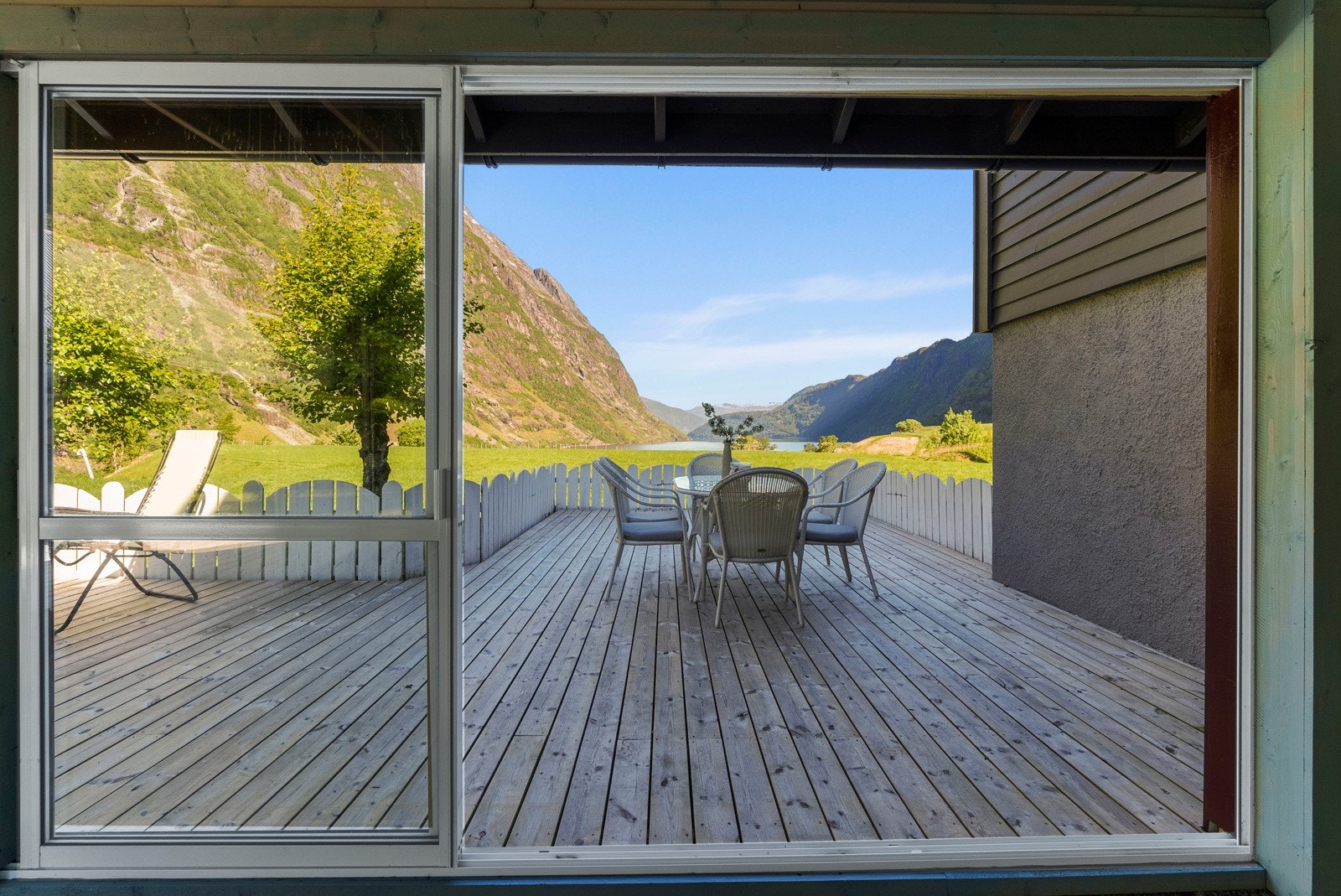 Store skyve-dører i glass gjør at en kan åpne opp to av veggene i hagestua Galleribilde