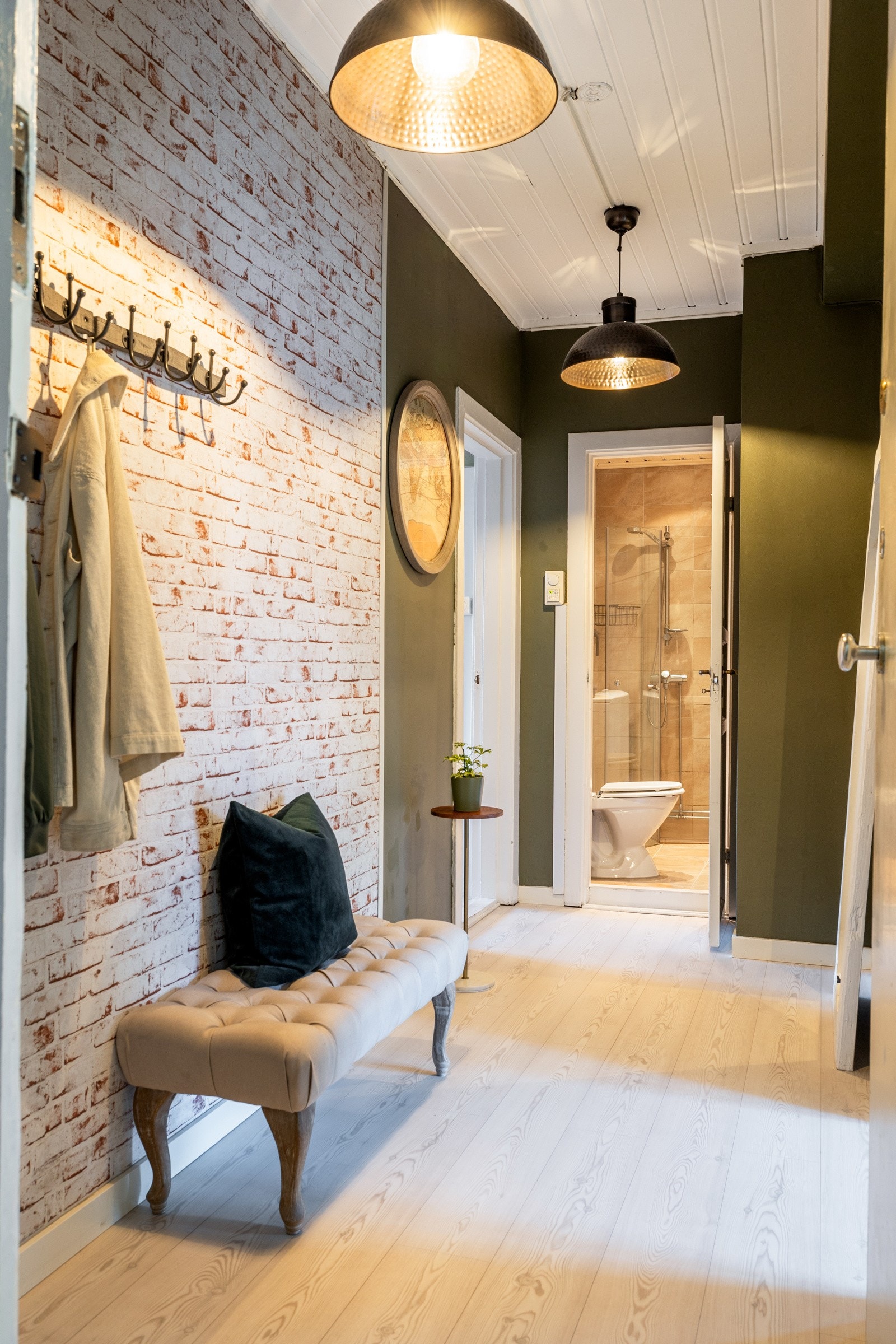 Leiligheten ligger høyt i byggets toppetasje og har en romslig entré Galleribilde