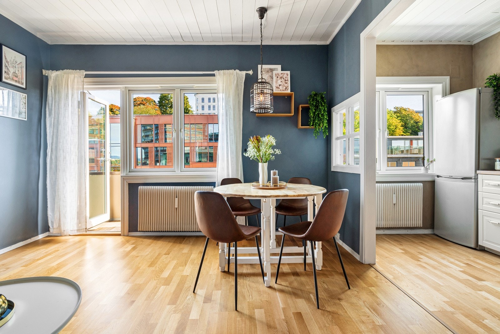 Leilighetens stue ligger i åpen løsning med kjøkkenet, og er et sosialt og innbydende allrom Galleribilde