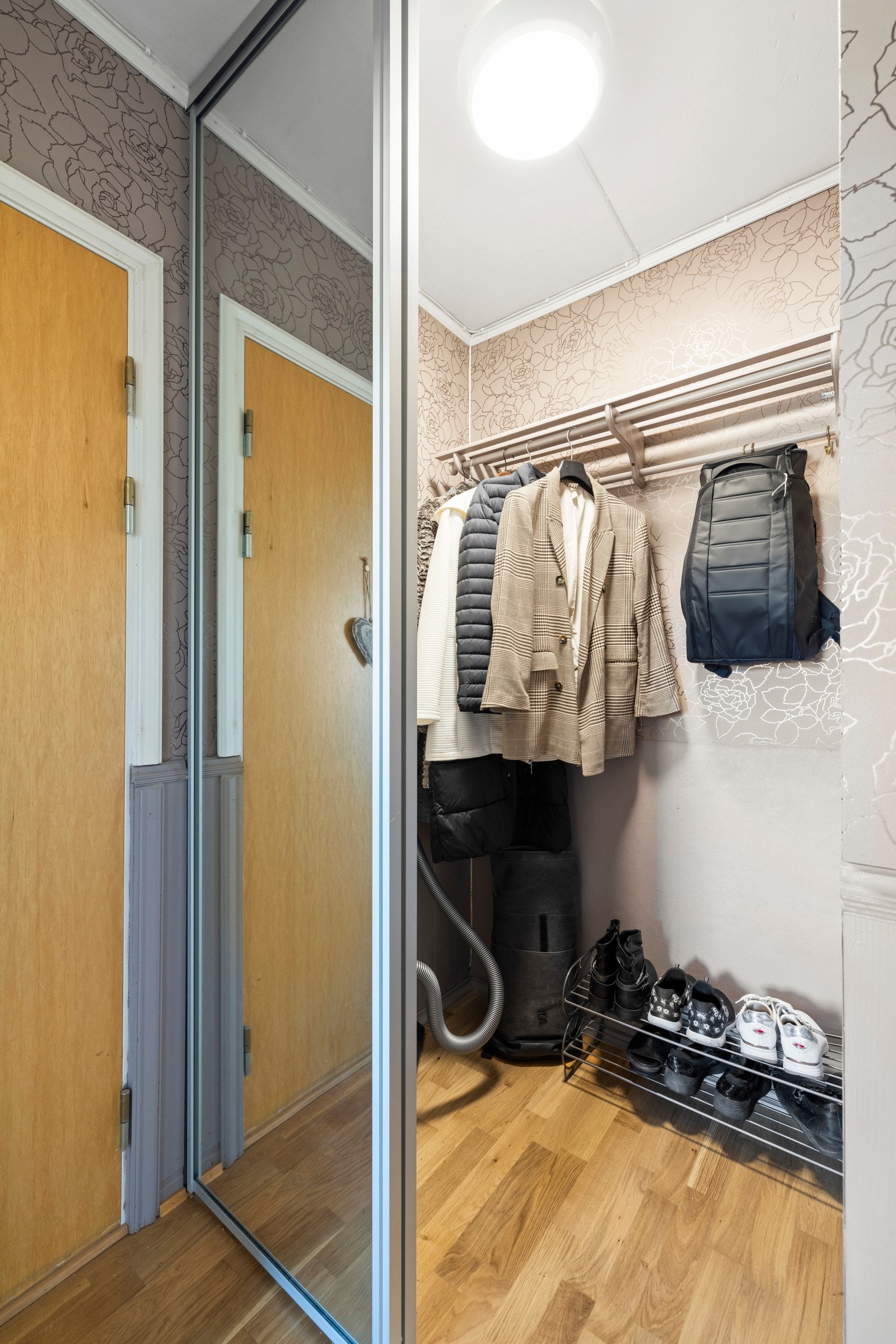 Bak skyvedører med speilfronter er det oppbevaringsplass til sko, jakker og annet i form av justerbare hyller og hattehylle med heng Galleribilde