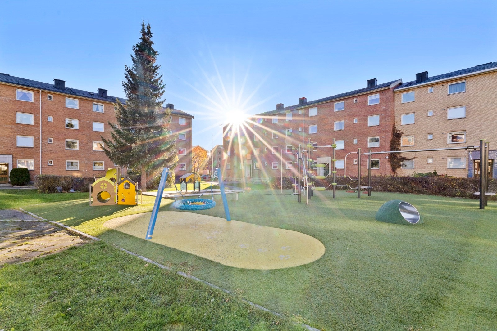 Deler av området er inngjerdet, og blant det grønne, godt skjermet av byggene, er det en stor lekeplass til glede for de små Galleribilde