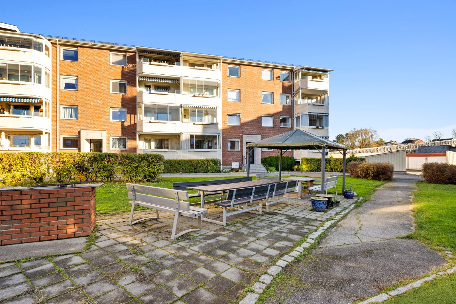 Like ved siden av er det hellelagt markterrasse med langbord, paviljong og grill for sosial hygge Galleribilde