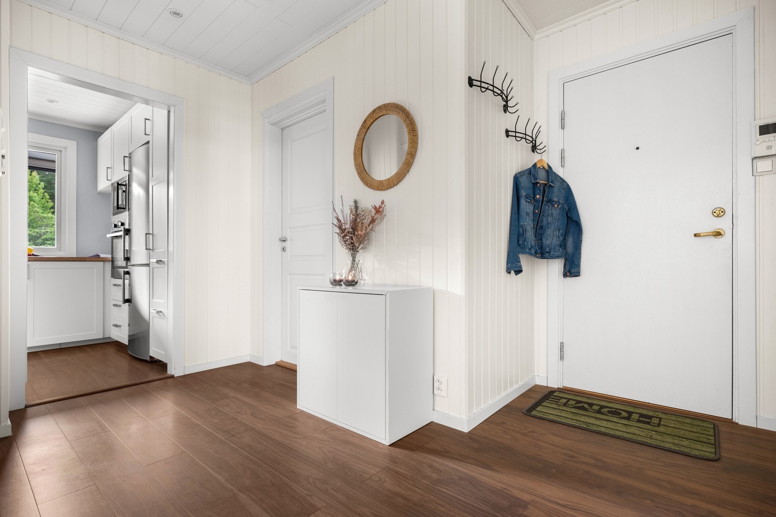 Entreen er innbydende og i direkte tilknytning til både stuen og kjøkkenet, med det samme mørke 1-stavs laminatgulvet. Galleribilde
