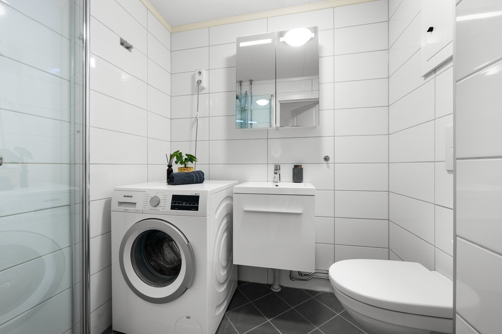 Badet ble oppgradert i regi av borettslaget i 2017 og har mørke gulvfliser kombinert med hvite fliser på veggene. Galleribilde