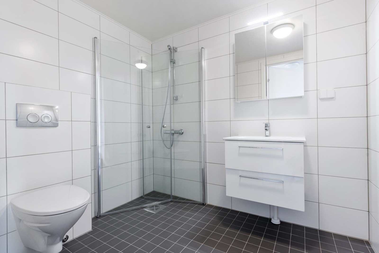 Lyst og romslig baderom med opplegg for vaskemaskin. Galleribilde