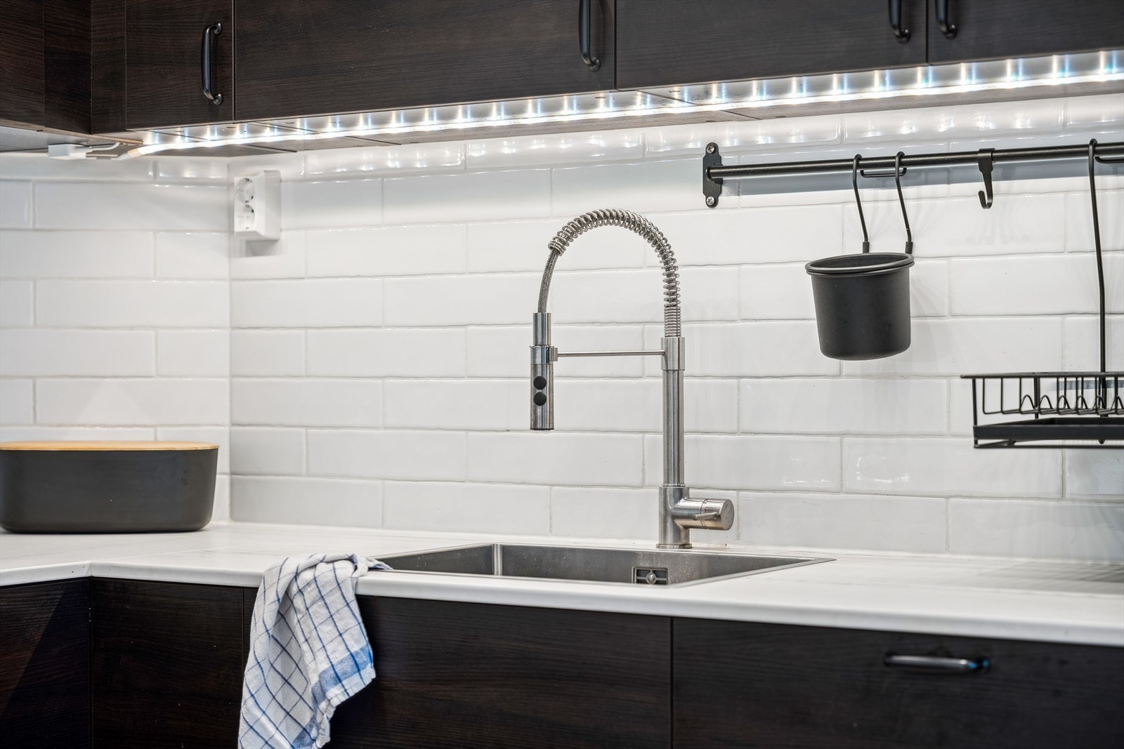 Ventilator med kullfilter og integrerte hvitevarer som induksjonstopp, stekeovn, mikrobølgeovn, oppvaskmaskin og kjøleskap sikrer funksjonalitet og et ryddig uttrykk. Galleribilde