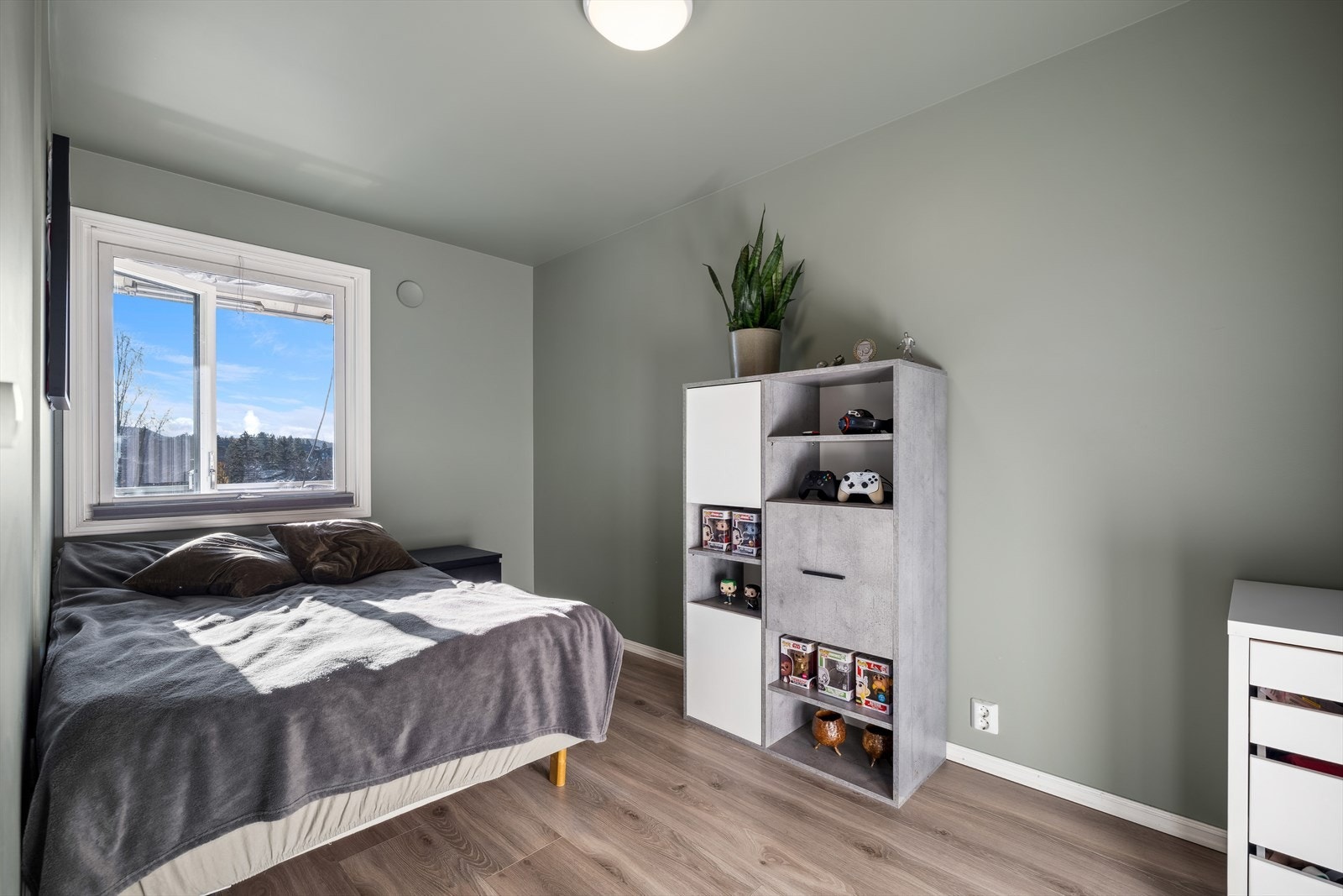 I første etasje finner vi ett soverom med vindu mot balkongen, som har adkomst fra stuen. Dette rommet har plass til en dobbeltseng og ønsket soveromsmøblement, samt et garderobeskap for praktisk oppbevaring. Galleribilde