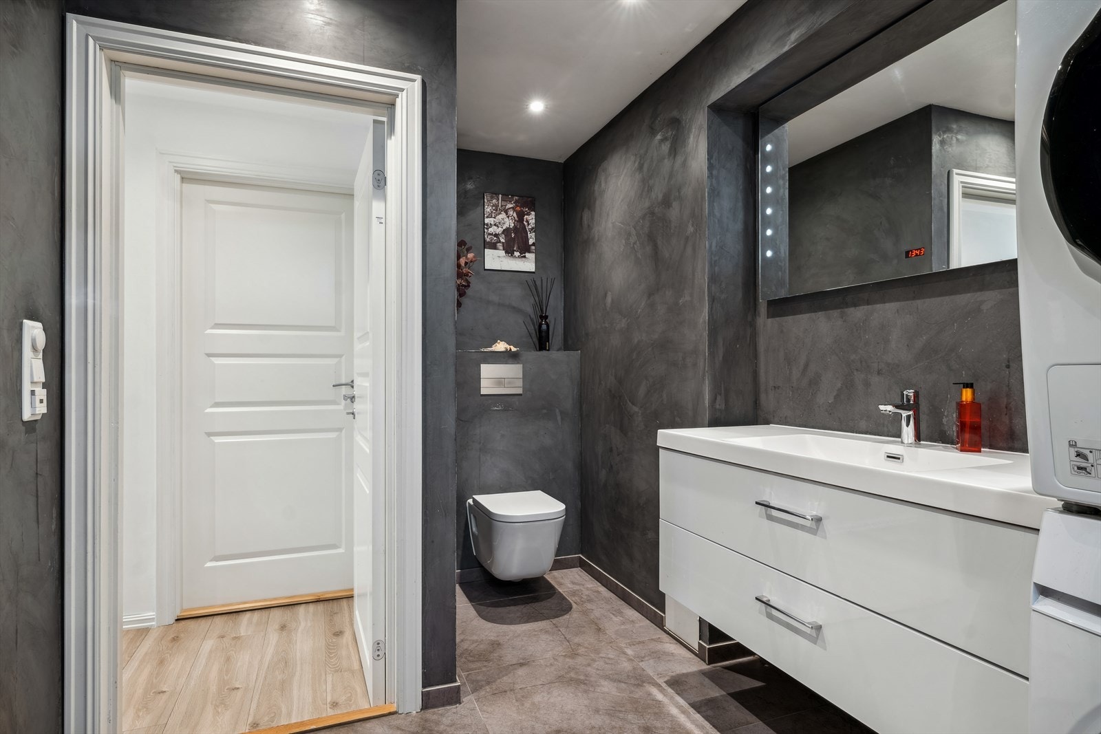 Det er opplegg for vaskemaskin, noe som gjør det enkelt å håndtere klesvasken. Varmekabler i gulvet gir ekstra komfort, og rommet er lys og innbydende. Galleribilde