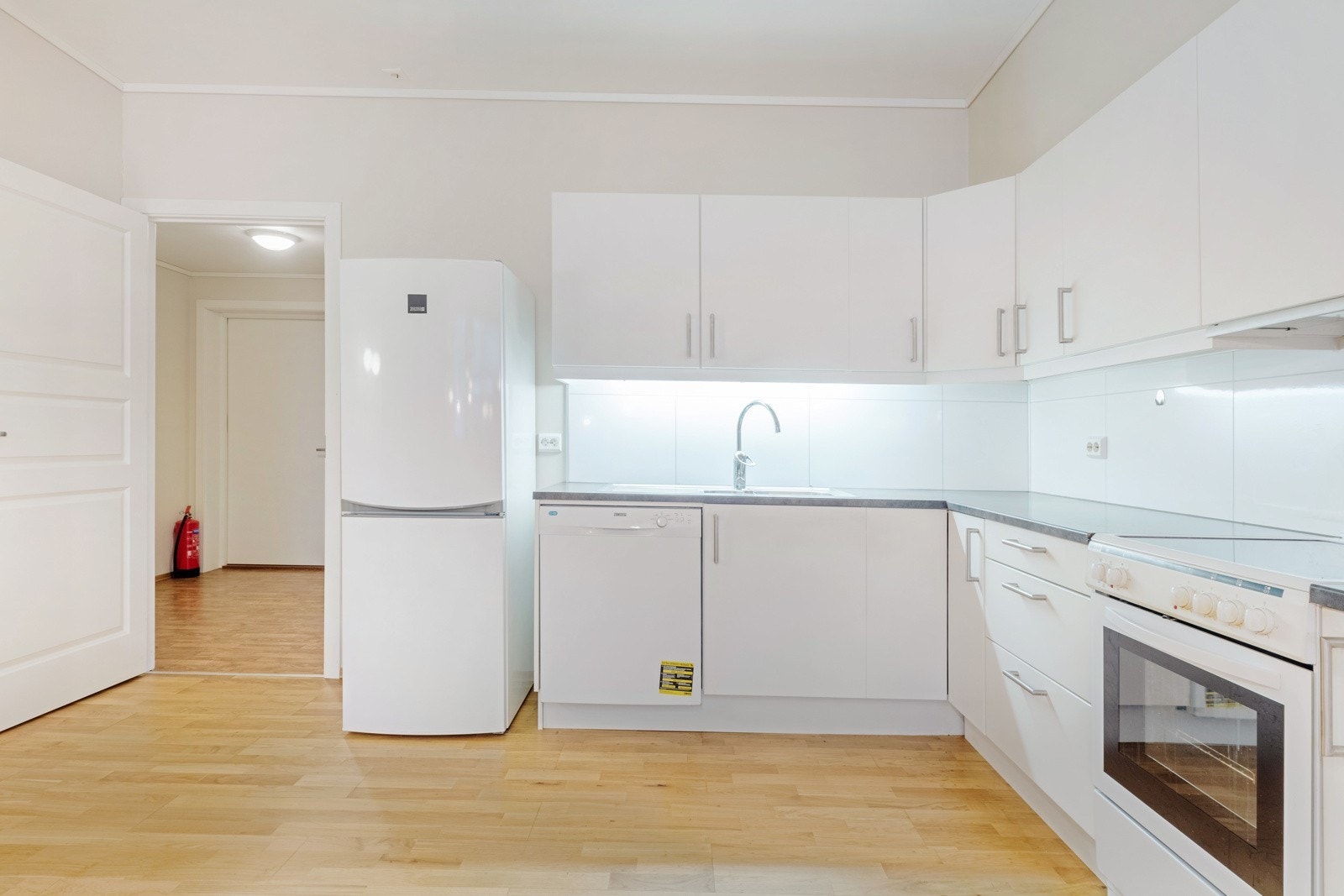 Kompakt og funksjonelt kjøkken med plass til eiga spisegruppe som også naturleg delar rommet inn i soner Galleribilde