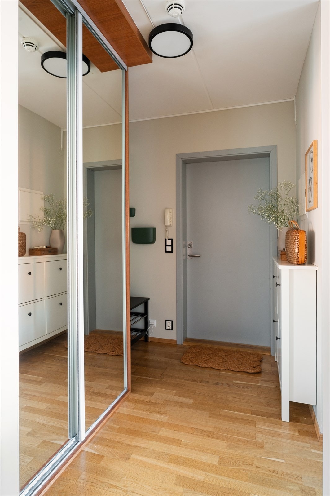 Innbydende entré med god plass til sko og jakkeavheng i plassbygd skyvedørsgarderobe med speildører Galleribilde