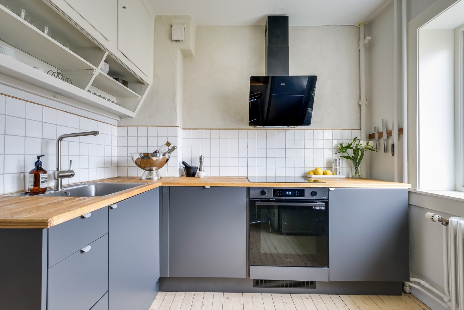 Benkeplaten er av heltre, og det er lagt pene fliser mellom benkeplate og overskap. Galleribilde