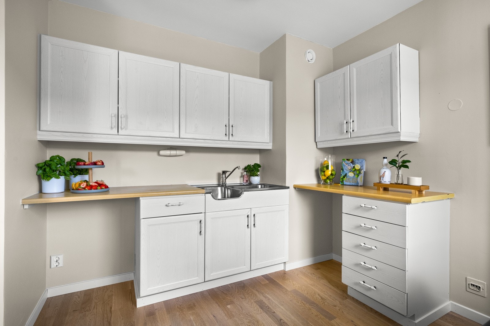 Kjøkkeninnredningen er eldre med hvite, profilerte fronter, laminert benkeplate, oppvaskkum og skyllekum. Galleribilde