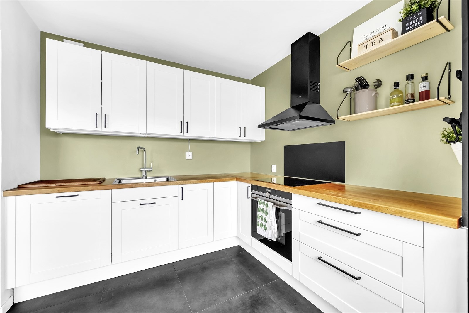 Pent, tidløst kjøkken med integrert platetopp, komfyr og oppvaskmaskin. Galleribilde