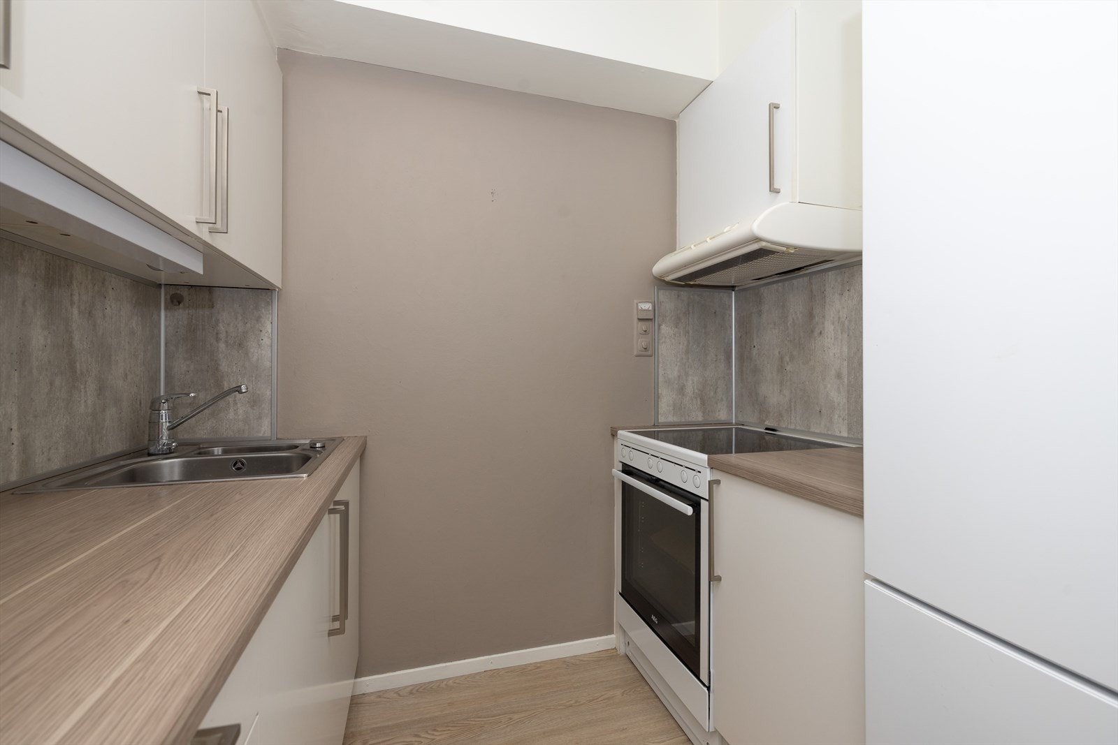 Kjøkken med skap- og benkeplass på begge sider av rommet. Galleribilde