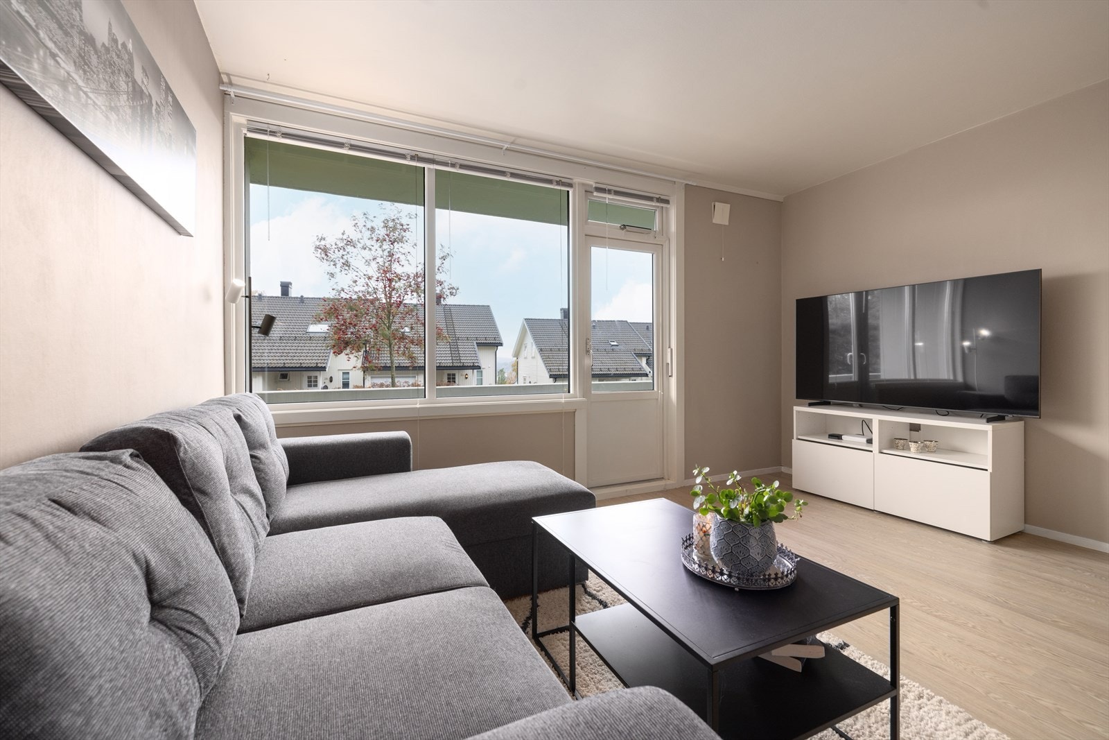 Koselig stue med plass til sofa og mediemøblement. Vinduene slipper rikelig med naturlig lys inn. Galleribilde