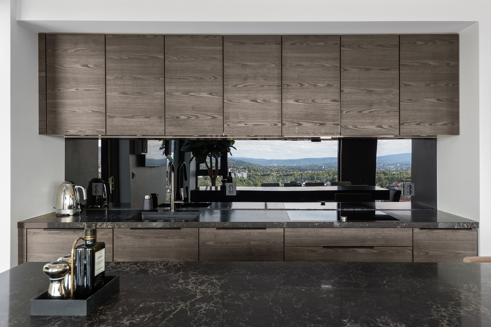 Romslig og flott spisestue med store vindusflater mot utsikten, åpen kjøkkenløsning med lekker innredning fra Poggenpohl, samt utgang til markterrasse/hagedel tilseksjonert leiligheten Galleribilde