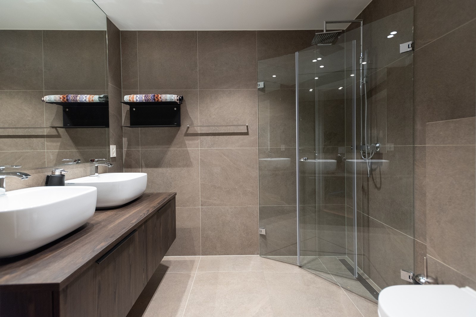 Gjestebad med stor dusj-sone, vegghengt toalett og dobbel servant, samt inngang direkte fra hallen Galleribilde