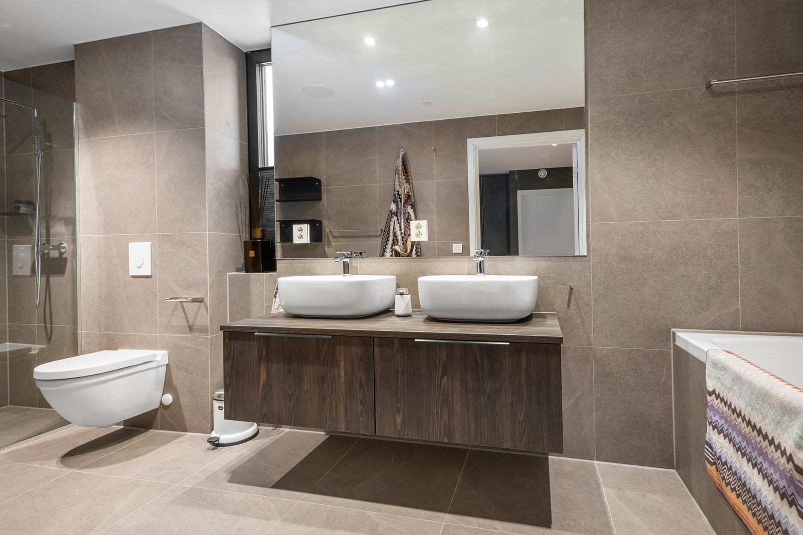 Lekkert bad en-suite med stor dobbel-dusj sone, dobbel servant, samt vegghengt toalett og badekar, etc. Galleribilde