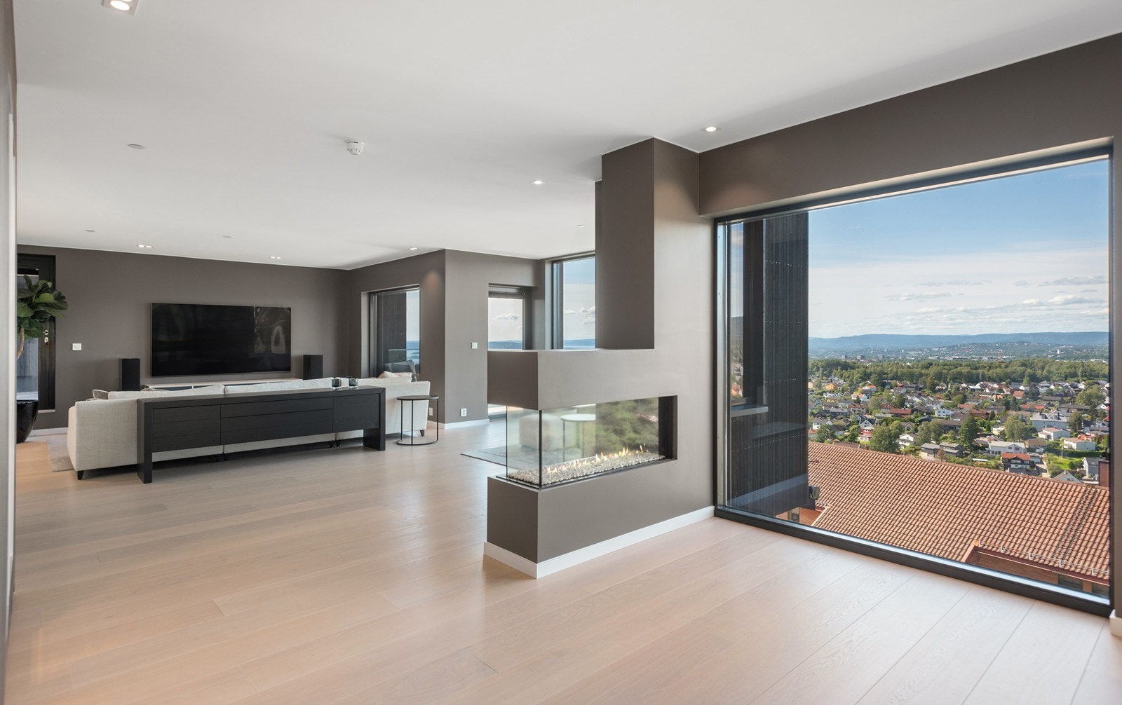 I den gigantiske stuen bidrar gasspeisen til et naturlig skille mellom spisestue og stuedel Galleribilde