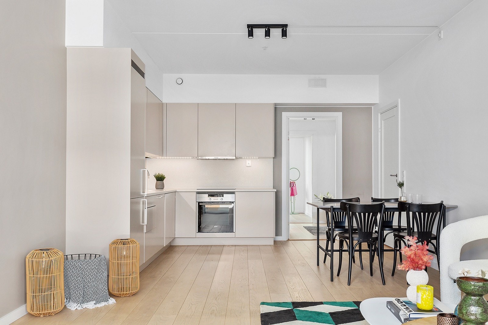 Kjøkken sett fra stue med medfølgende, integrerte hvitevarer. Galleribilde