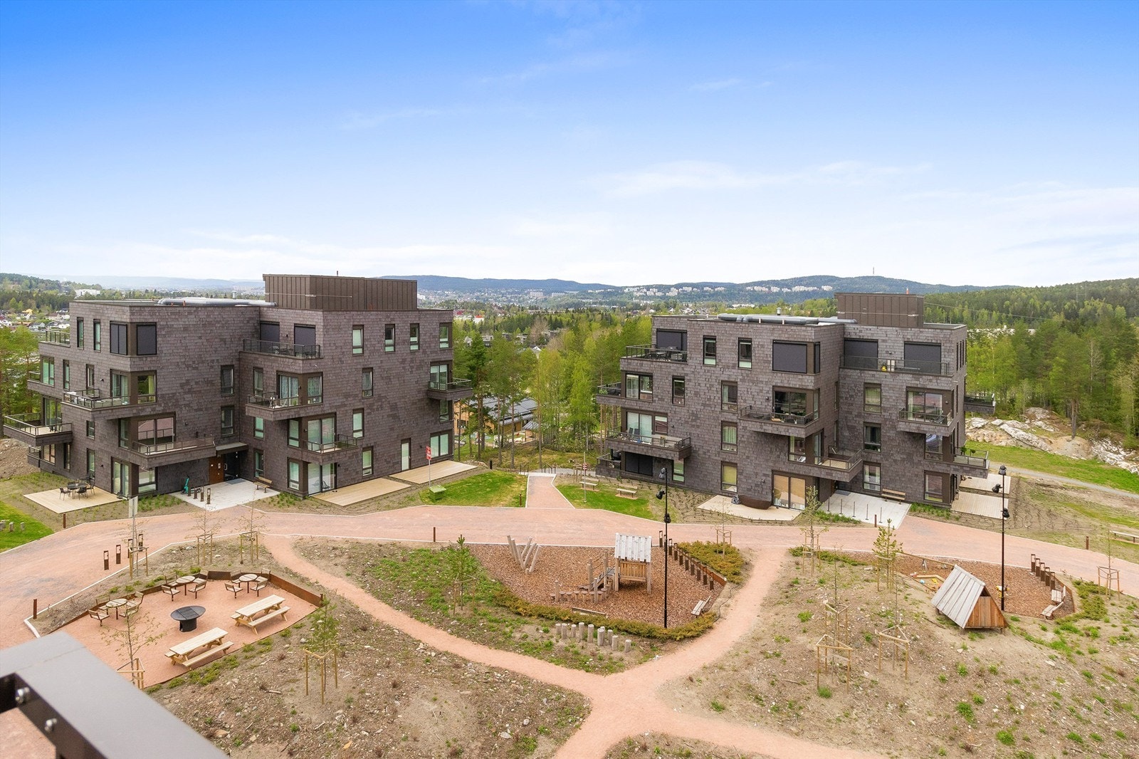 Opparbeidet fellesareal med sittegrupper og lekeplass Galleribilde