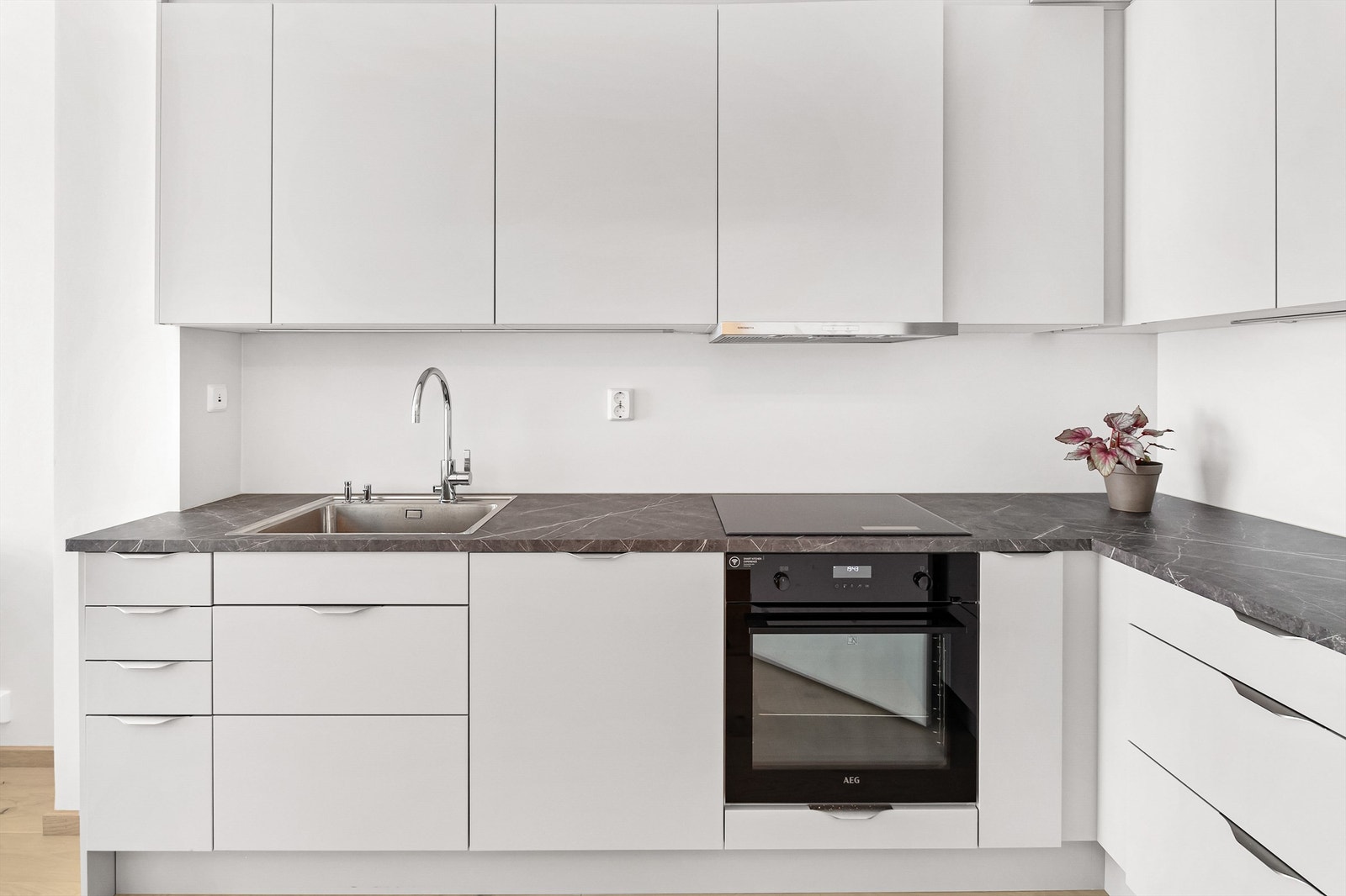 Kjøkken med integrerte hvitevarer som stekeovn, koketopp, oppvaskmaskin og kjøl-fryseskap Galleribilde