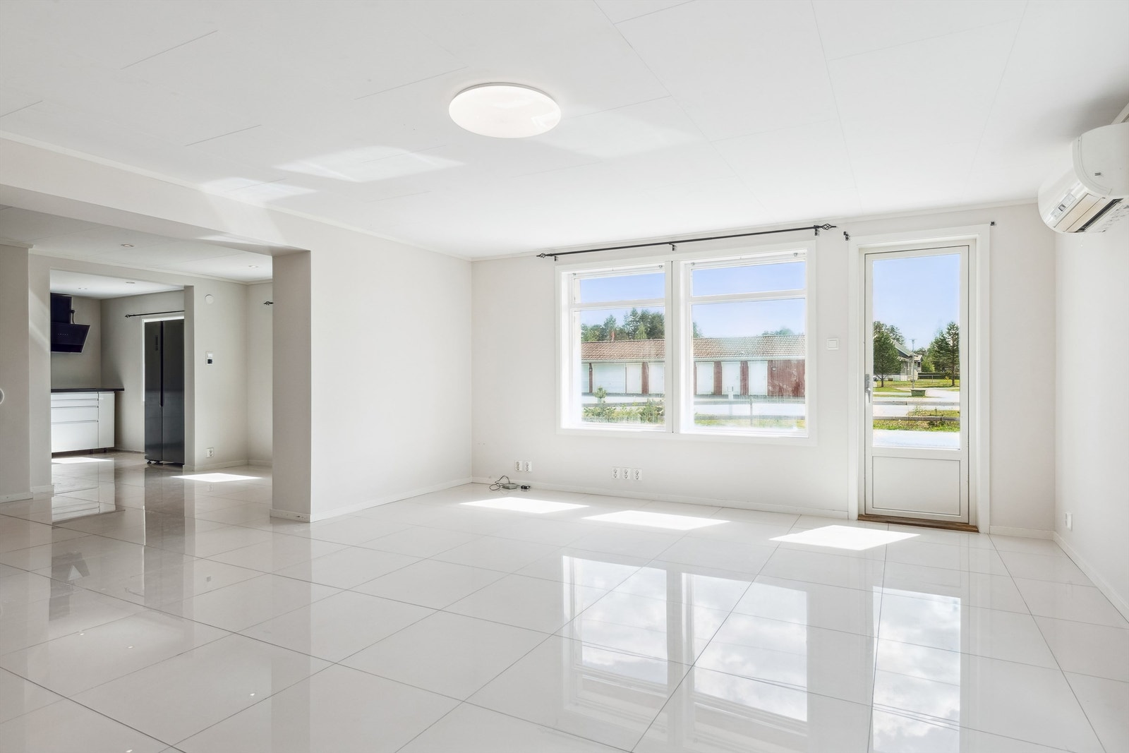 Stue og kjøkken med delvis åpen løsning, med flislagt gulv. Galleribilde