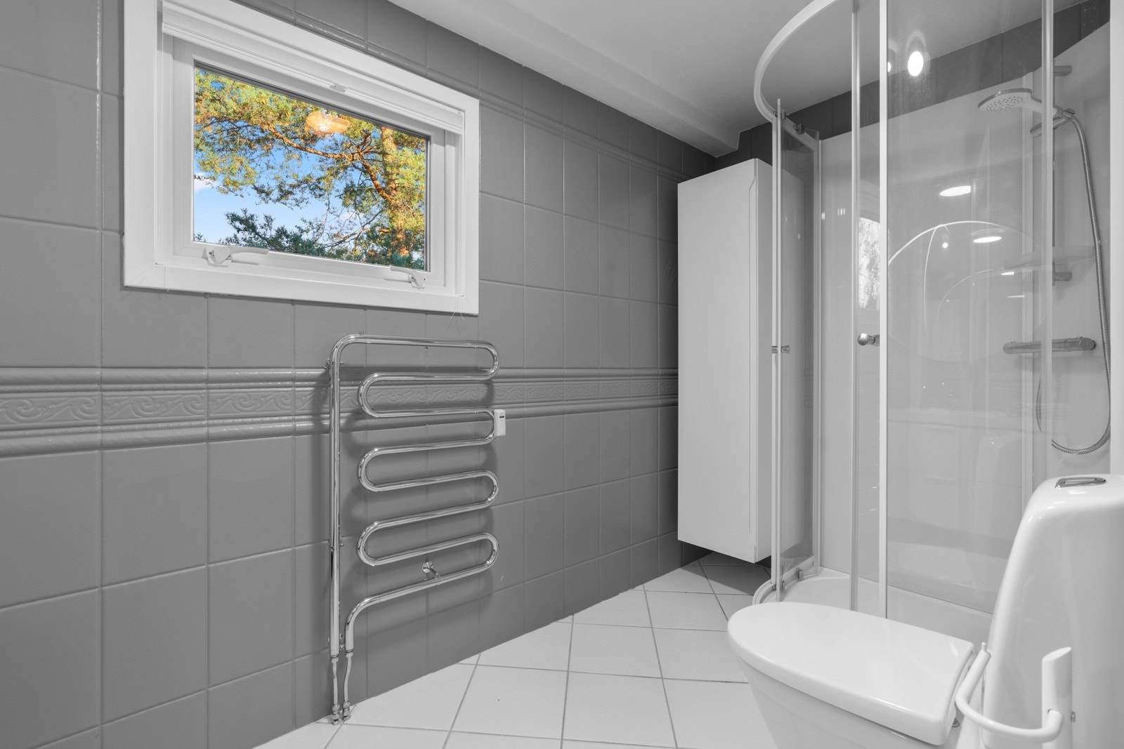 Baderommet inneholder dusjkabinett og håndkletørker. Galleribilde