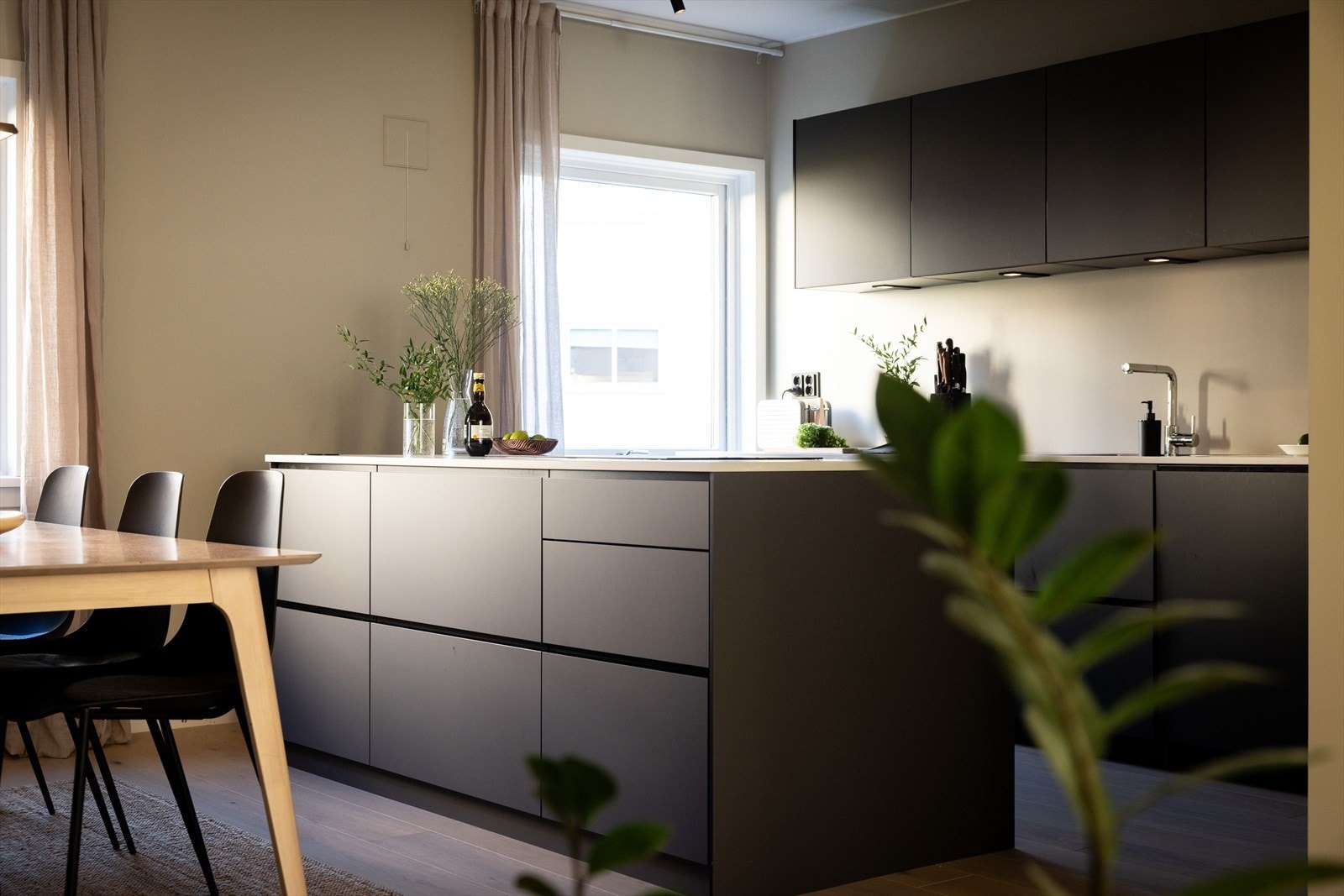 - Kjøkkeninnredning med glatte fronter. Laminat benkeplate med nedfelt vaskekum. Belysning over benkeplaten - Galleribilde