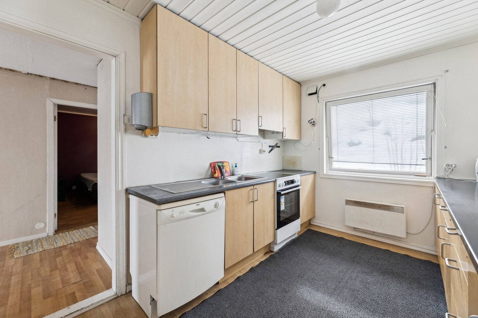 Kjøkkenet har en separat beliggenhet med tilgang fra stuen, og er utstyrt med en tredelt innredning, bestående av skap med slette fronter, en laminert benkeplate og en dobbel vaskekum. Galleribilde