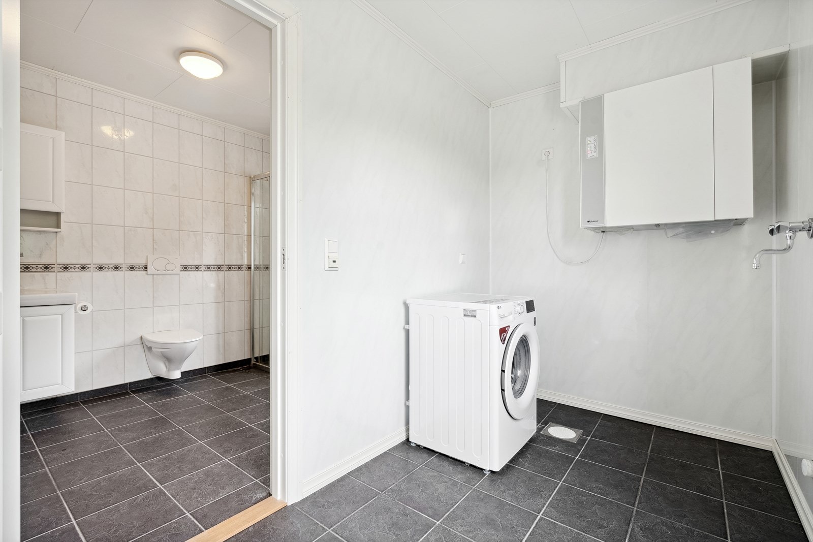 Vegg i vegg med badet ligger vaskerom. Vaskerommet har også egen inngang fra tunet. Galleribilde