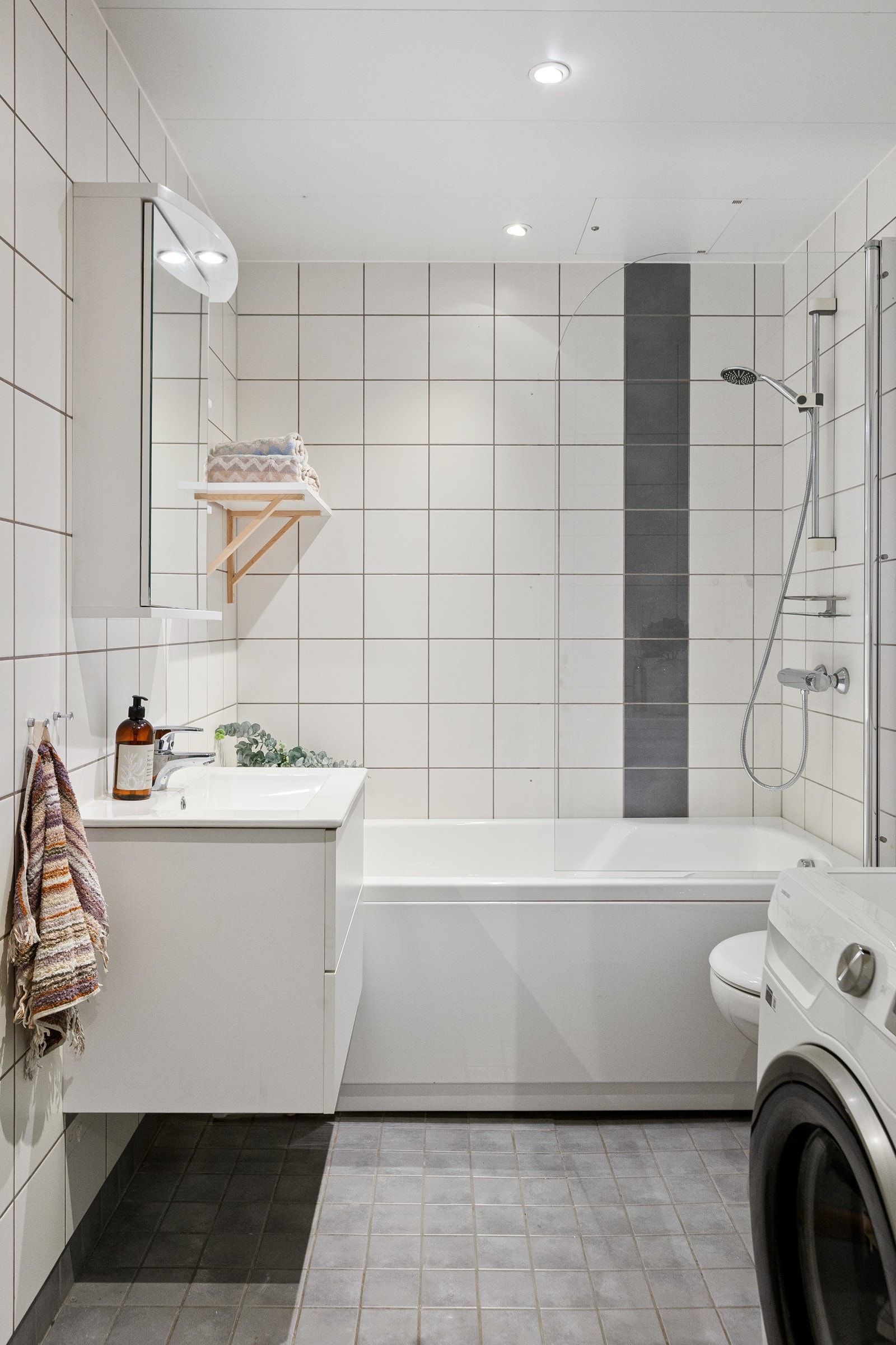 Innredningen består av vegghengt toalett, servant med benkeskap, overskap med speilfronter og dusj i badekar. Videre på badet er det opplegg for vaskemaskin. Galleribilde