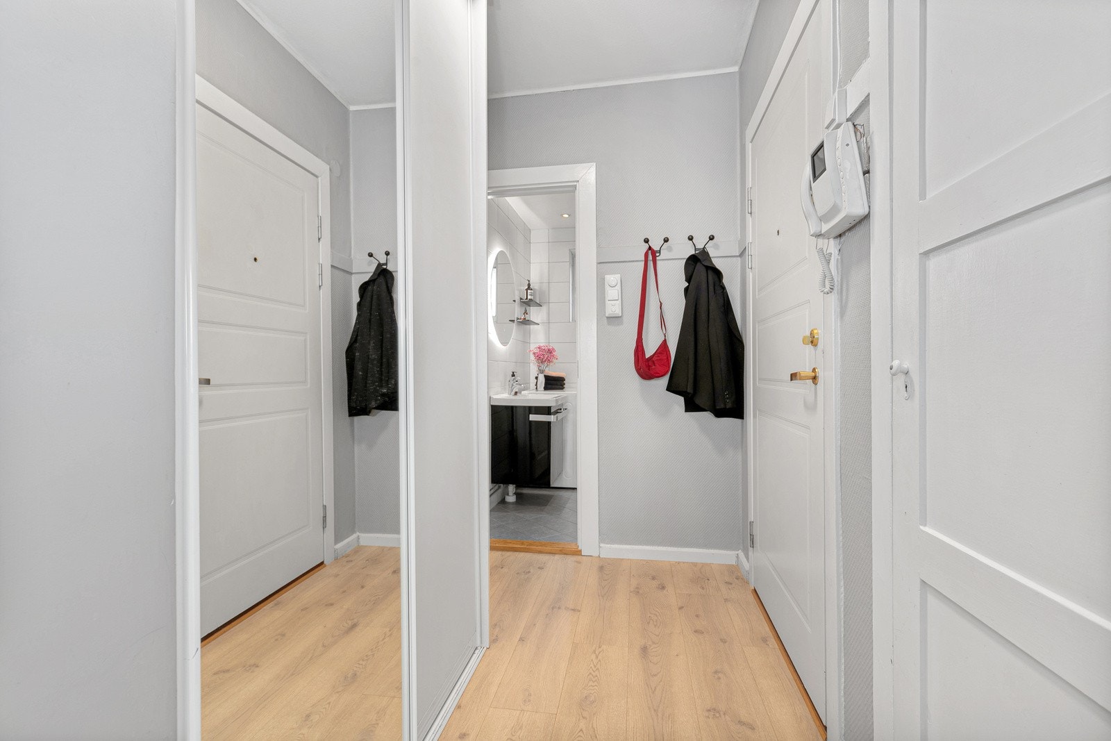 Romslig entré med lysmalte vegger og pent laminatgulv. Galleribilde