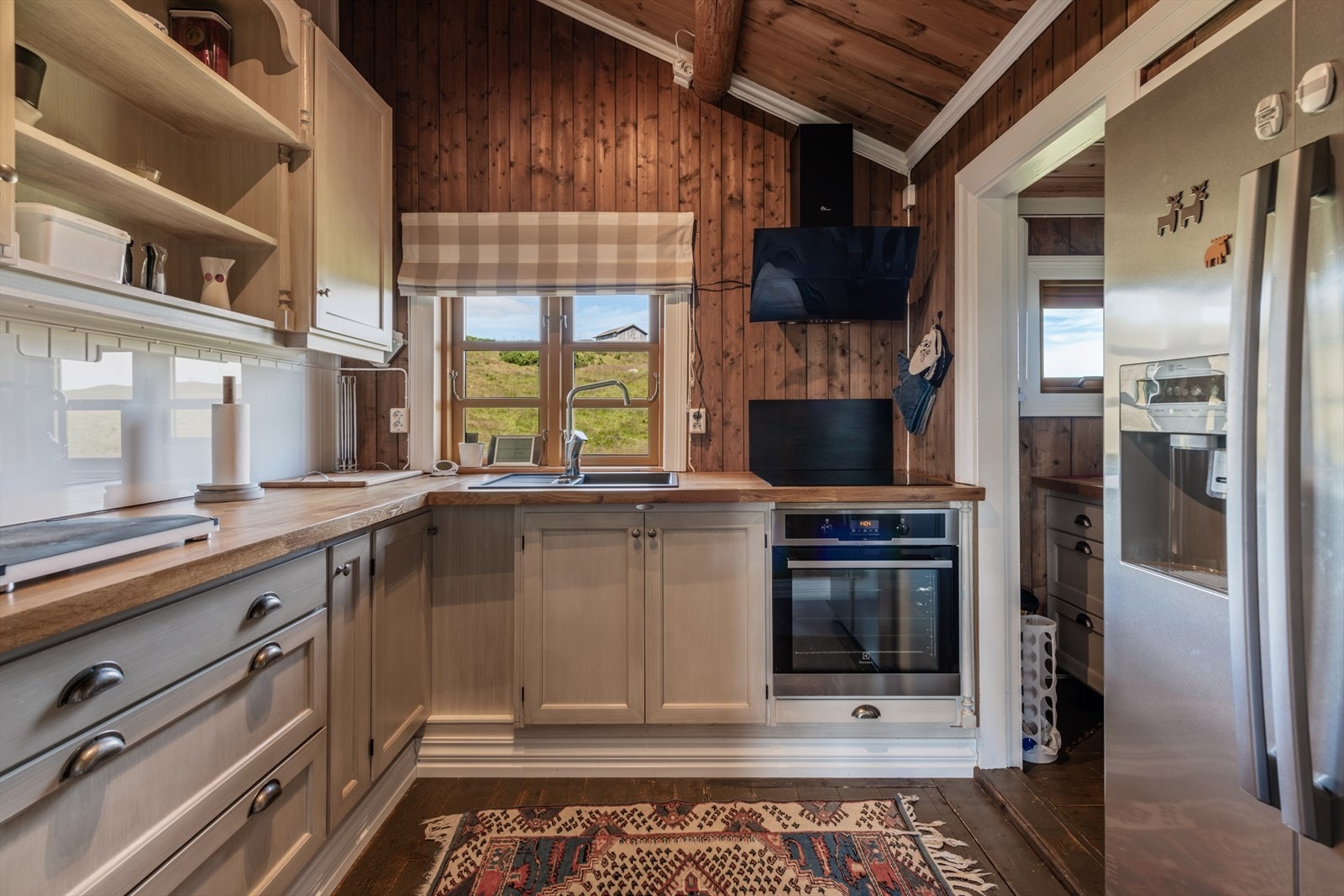 Kjøkkeninnredning med profilerte lakkerte fronter og heltre benkeplate. Galleribilde