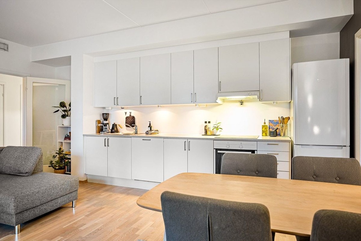 Pent, tidsriktig Sigdal-kjøkken som består av hvite fronter og benkeplate i laminat. Galleribilde