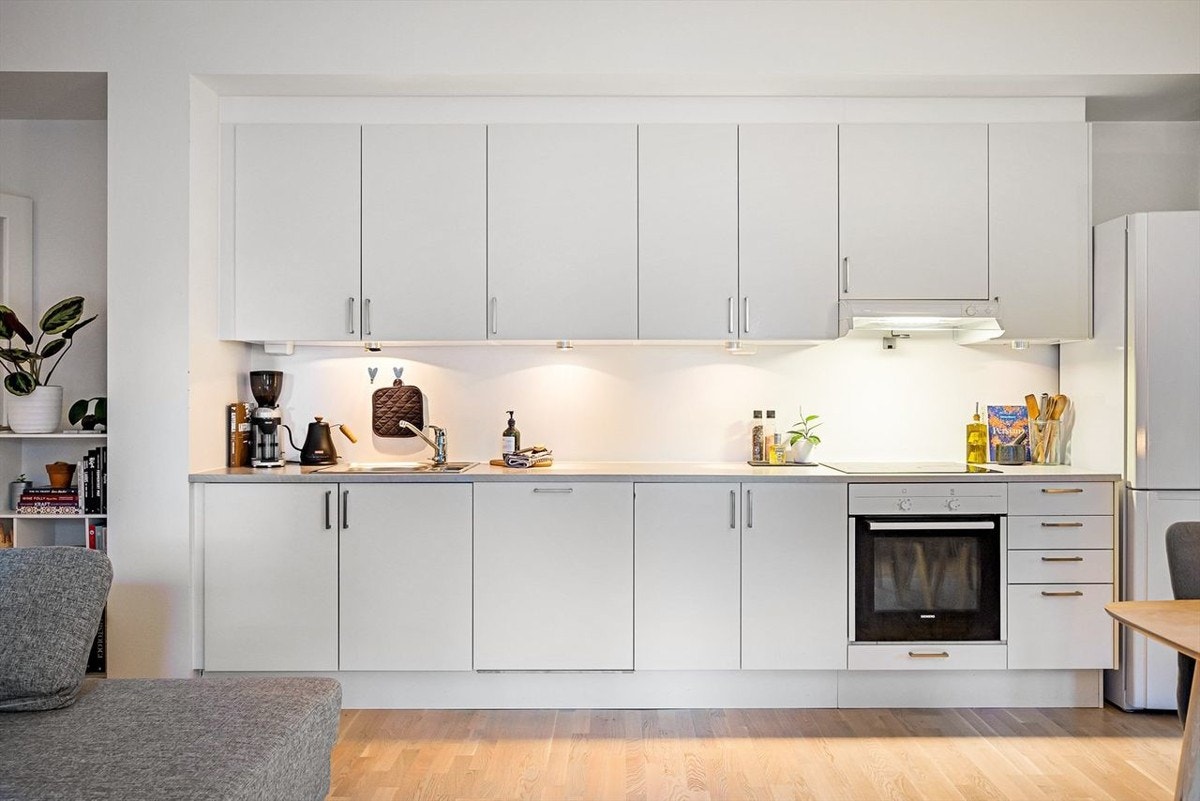 Moderne, integrerte hvitevarer: platetopp, stekeovn, oppvaskmaskin og kjøleskap med frys. Galleribilde