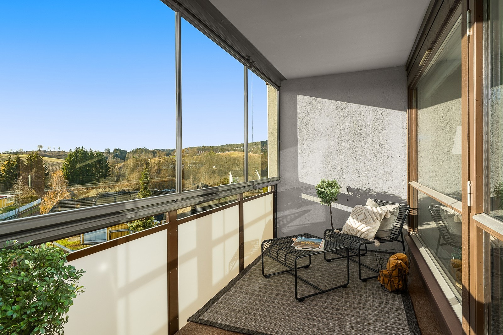 Utenfor stuen har leiligheten en innglasset balkong med vid utsikt, og vinduene kan skyves til side slik at sommeren slipper helt inn. Galleribilde